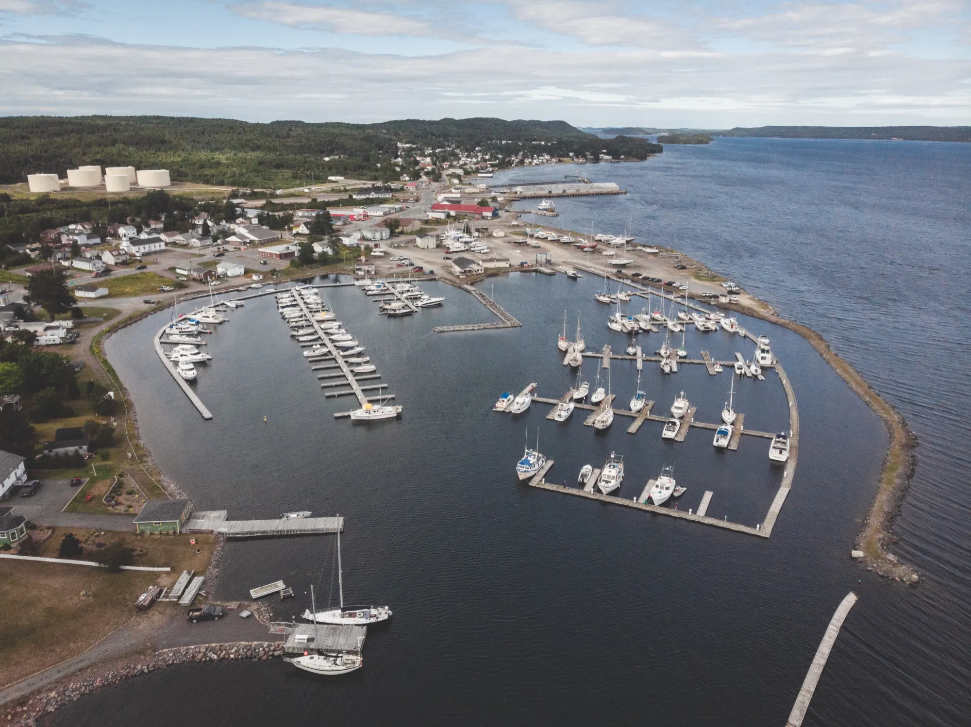 Aerial view of Lewisporte Marina, its floating docks lined with sailboats and motor cruisers in the sheltered harbour