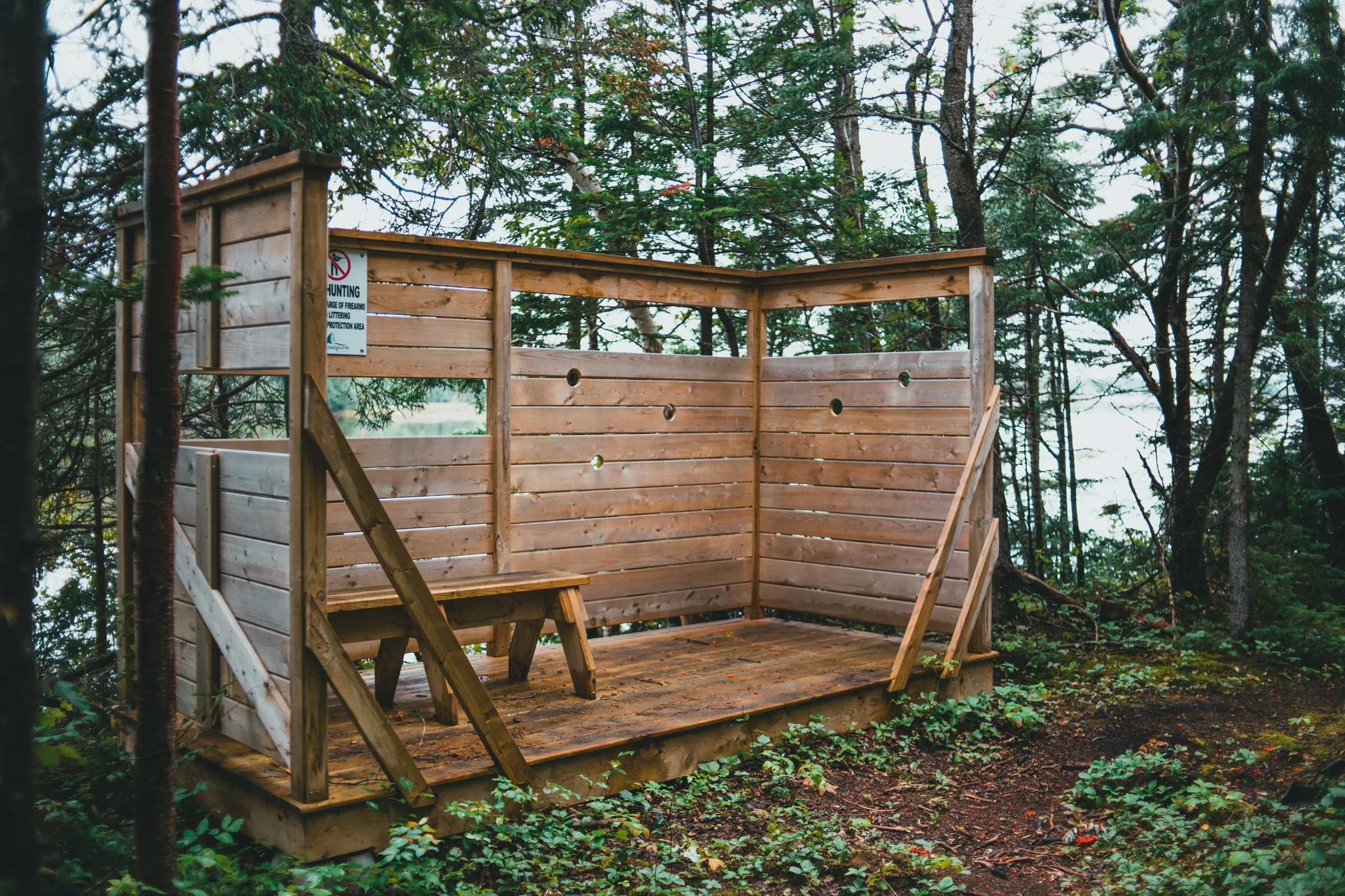 A wooden birdwatching blind with viewing slots, set along the Southwest Brook Estuary trail
