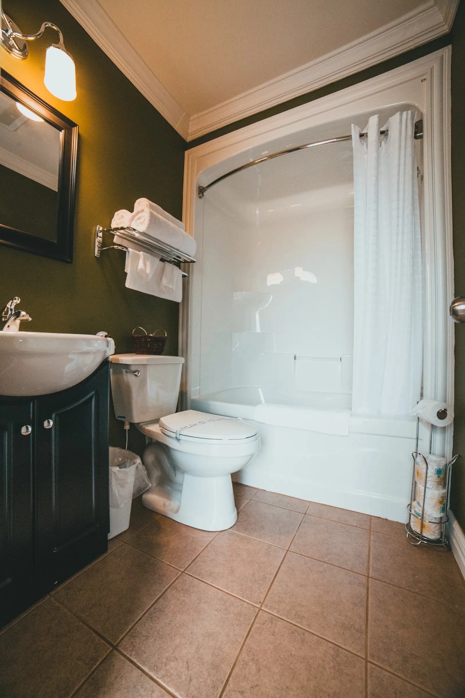 Guest bathroom with a dark vanity and vessel sink, a mirror above and a tub-shower behind a curved rod