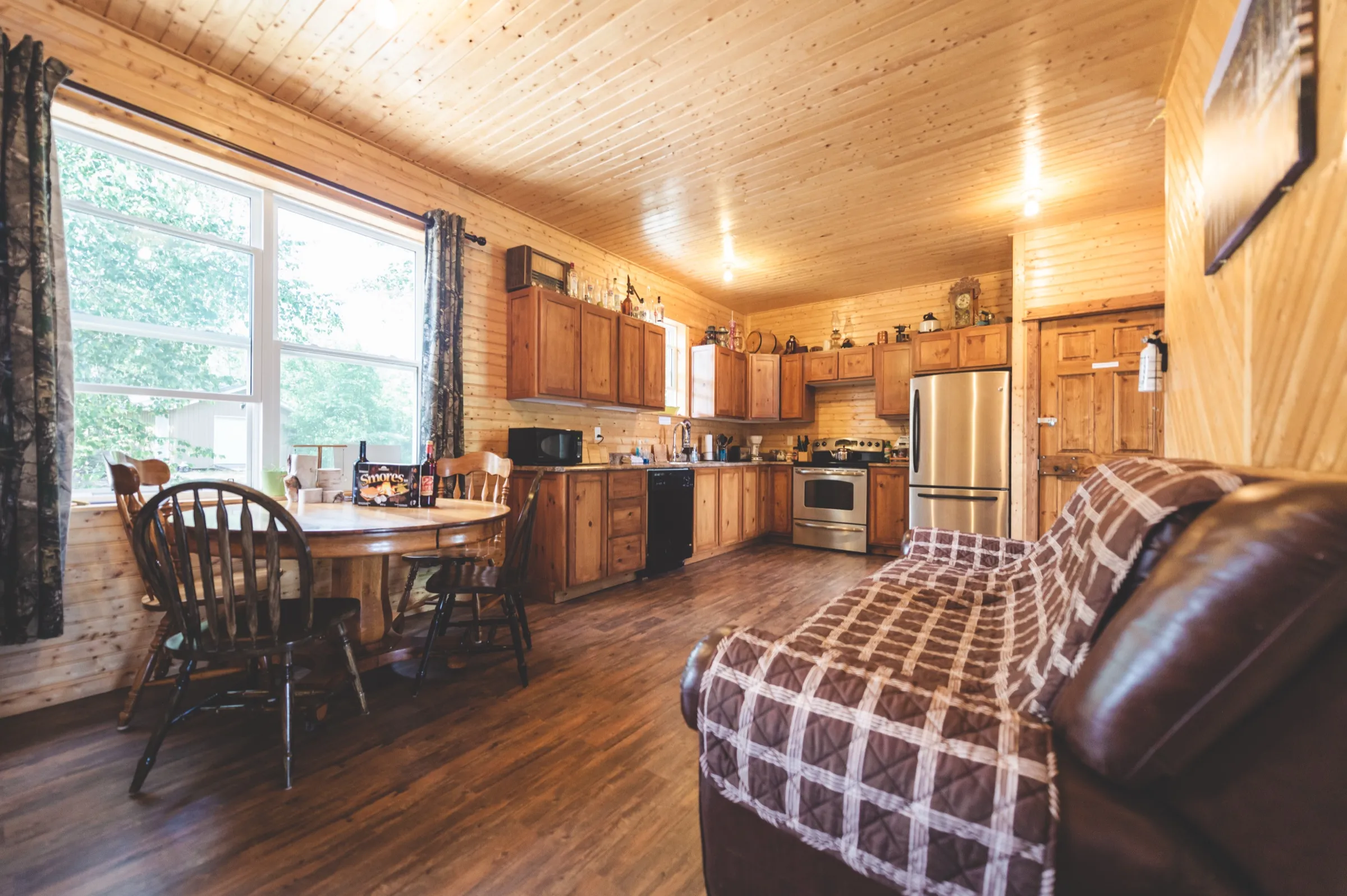 Full kitchen and dining area in the chalet, with wood cabinetry and a table set beneath the window