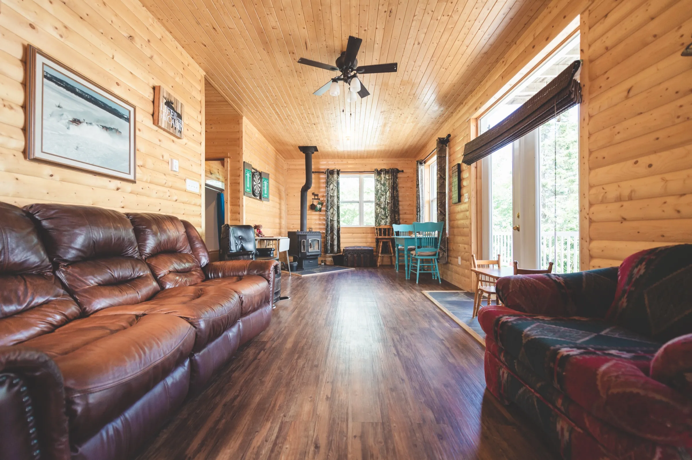 Chalet living room with pine walls, a wood stove in the corner and soft seating gathered around it