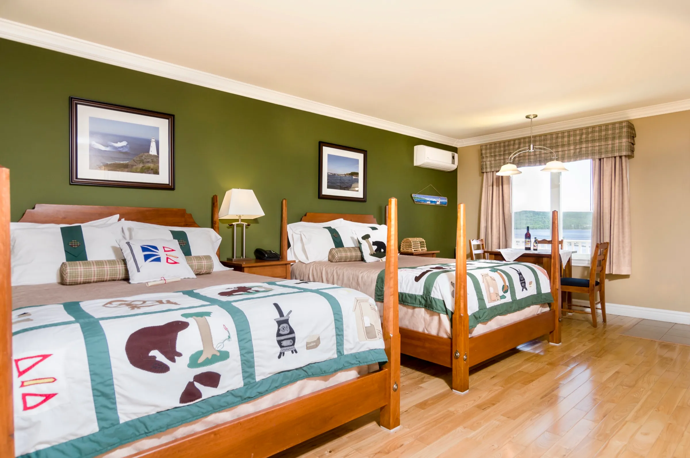 Two queen beds side by side under framed coastal photographs in the Family Suite