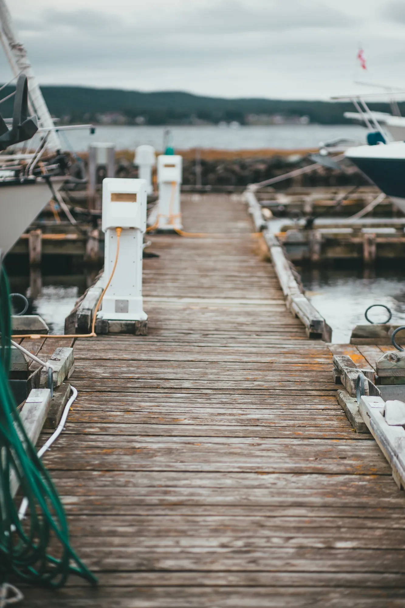 A floating dock walkway running out between moored boats