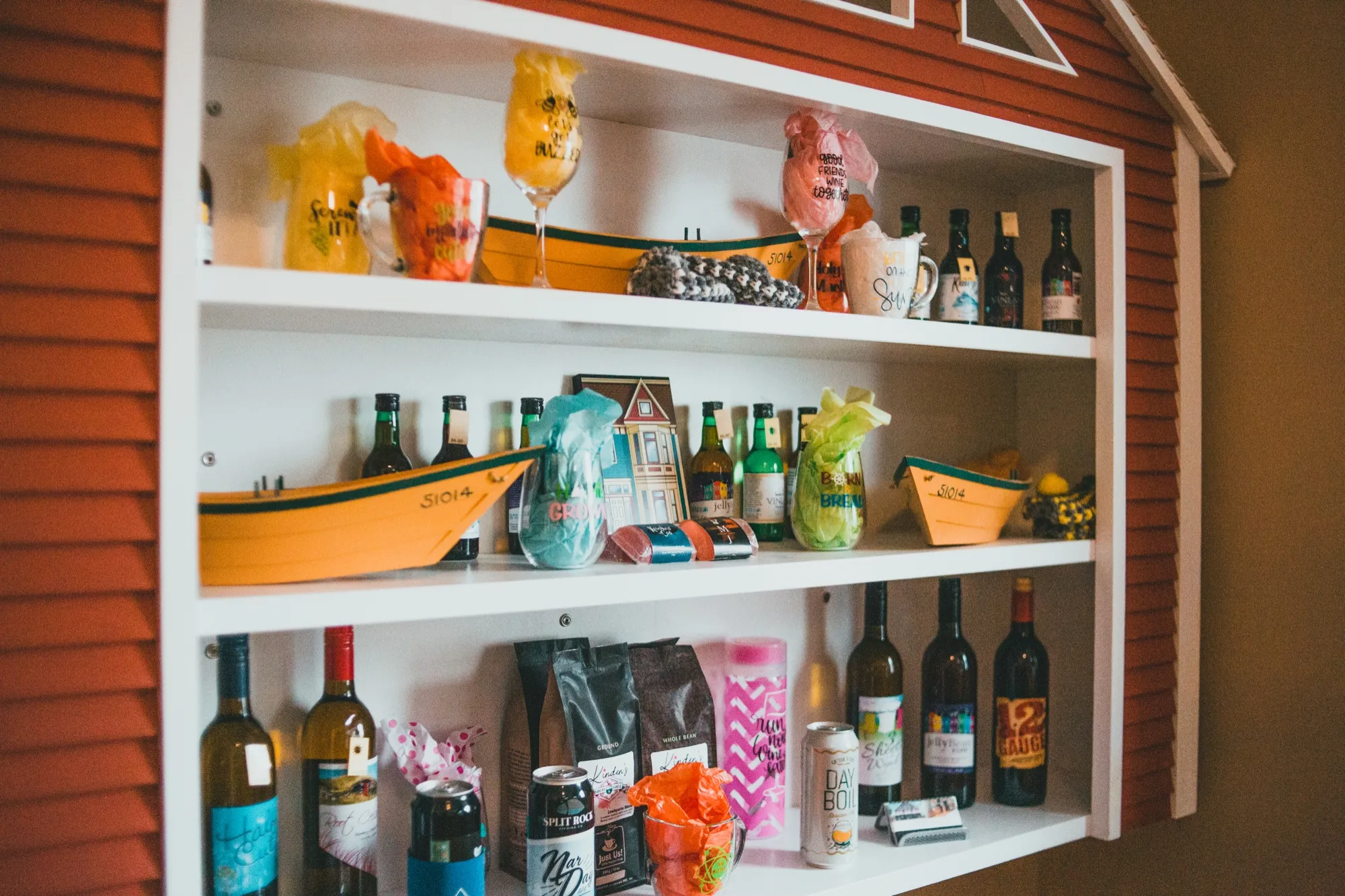 Shelves of local Newfoundland wines, painted dory models and souvenir glassware in the gift shop