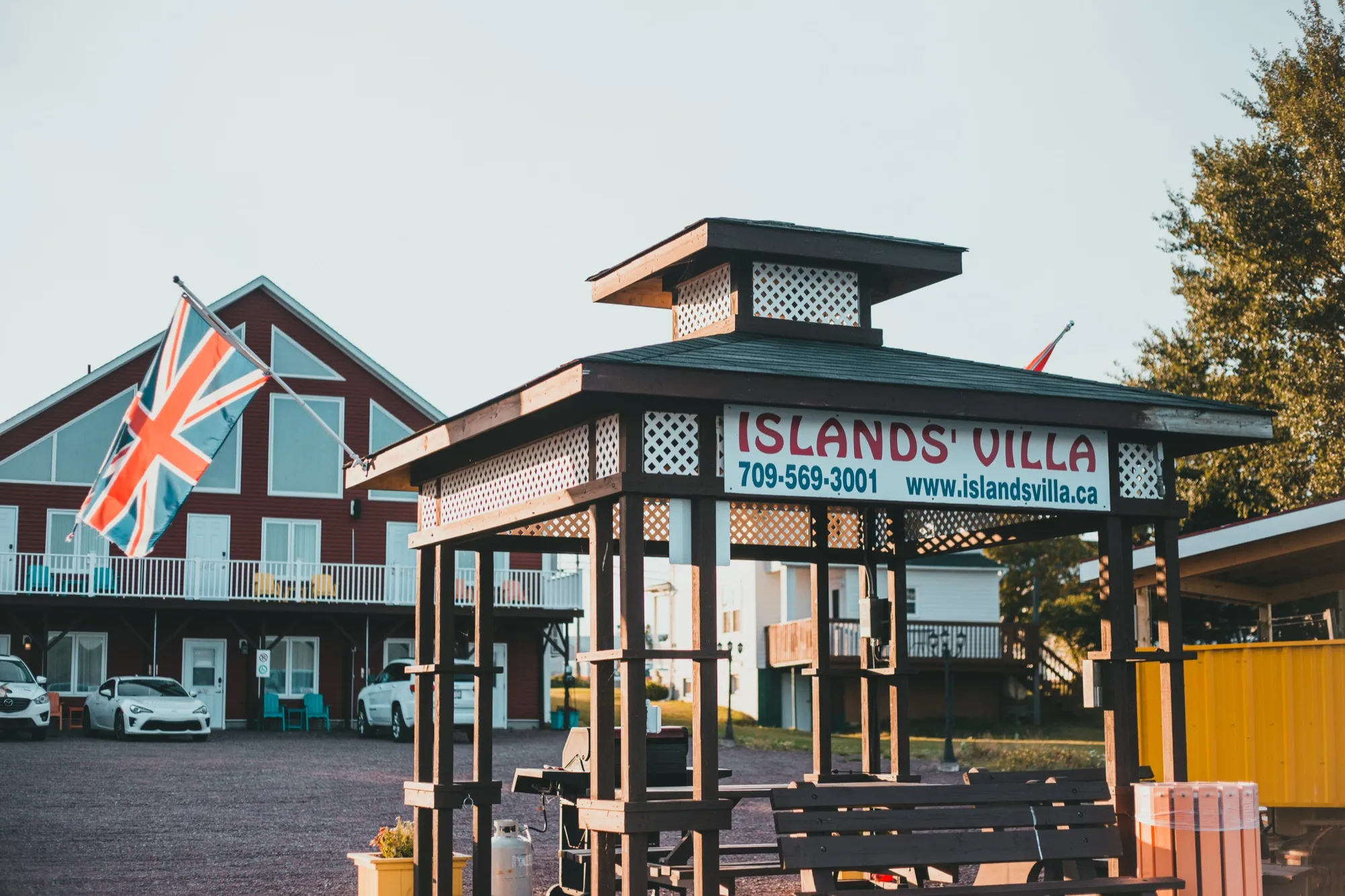 The waterfront gazebo carrying the Islands' Villa sign, with a flag flying and the villa behind