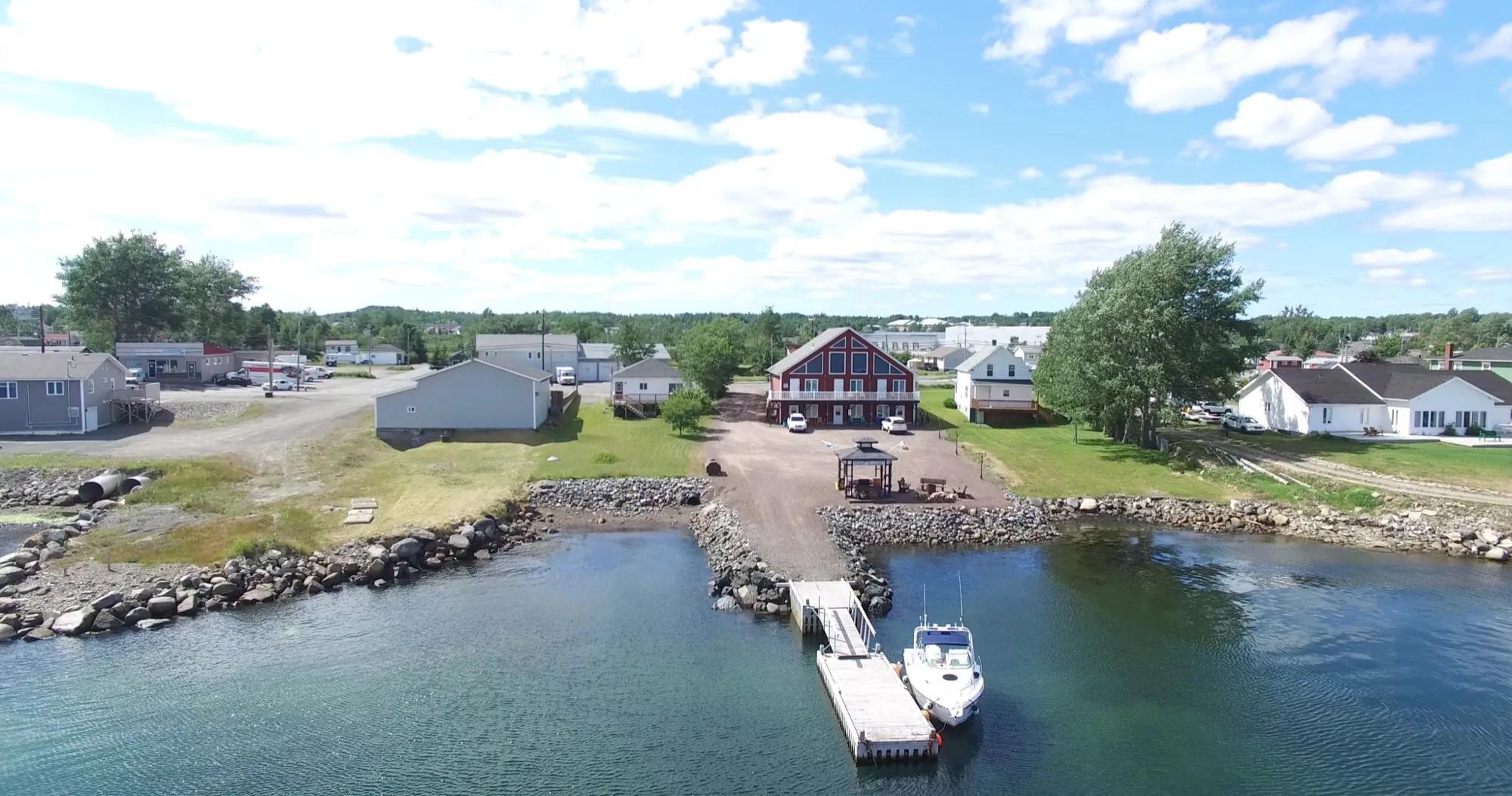 The villa grounds from the air, with the shoreline gazebo and a boat at the private dock